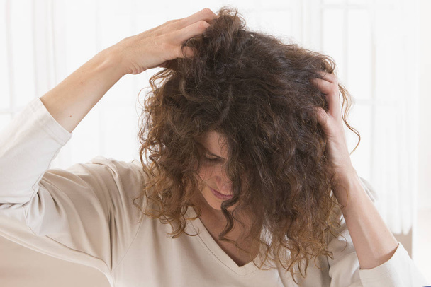 Woman suffering from an headache itching her head - Zdjęcie, obraz