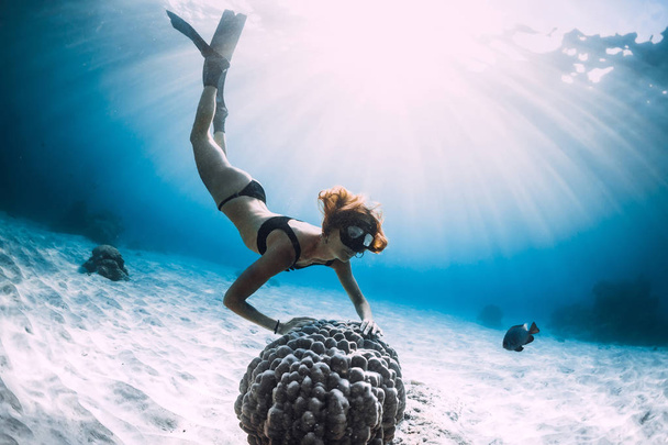 Vrouw Free Diver met vinnen en koraal. Duiken onderwater in blauwe oceaan - Foto, afbeelding