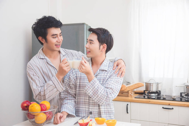 Jovem casal homossexual masculino bebendo leite para o café da manhã
  - Foto, Imagem