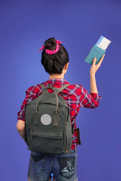 Woman travel. Young beautiful asian woman traveler holding passport and air ticket standing over blue. - Photo, Image
