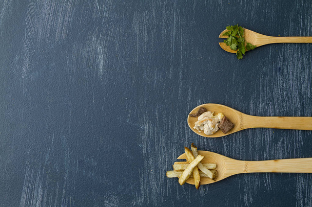 Cucharas de madera con Ingredientes para preparar Carne con Papas y koriander en un Fondo Azul desgastado con composicin minimalista y Espacio para Texto - Fotó, kép