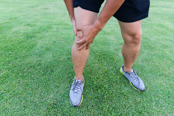 Τένοντα γονάτου κοινά προβλήματα σχετικά με το πόδι του ανθρώπου από άσκηση στο γήπεδο.   - Φωτογραφία, εικόνα