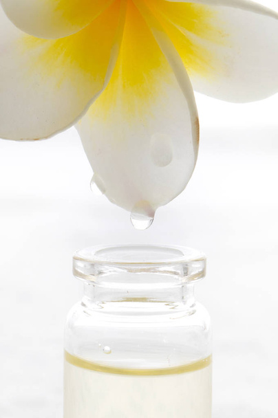 Essential oil dropping from flower to the bottle. Essence liquid cosmetic. Perfume.Aromatherapy. - 写真・画像