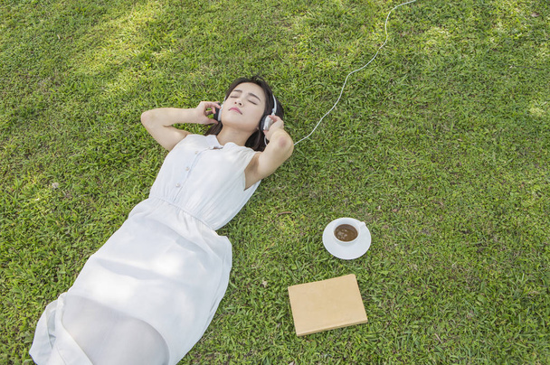  young asian woman in headphones in summer park  - Φωτογραφία, εικόνα