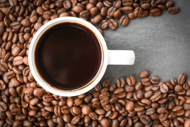 tazza di caffè su chicchi di caffè torrefatto sul fondo scuro vi
 - Foto, immagini