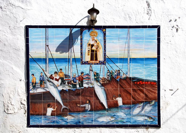 Cuadro tradicional de pesca de cerámica con los pescadores pasando por alto por Santa Catalina en una pared en el casco antiguo, Conil de la Frontera, España
. - Foto, imagen