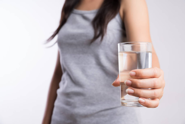 Ένα ποτήρι καθαρό μεταλλικό νερό στα χέρια της γυναίκας. Έννοια της περι - Φωτογραφία, εικόνα
