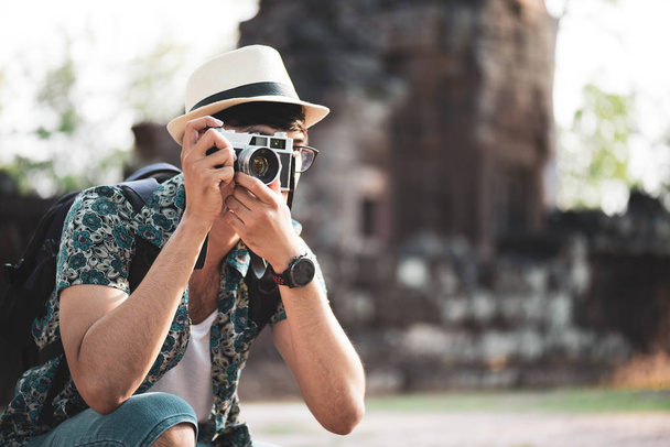 Young Man Photographer Traveler with backpack taking photo with his camera, Great wall in background at historical place. Lifestyle and travel concept. - 写真・画像