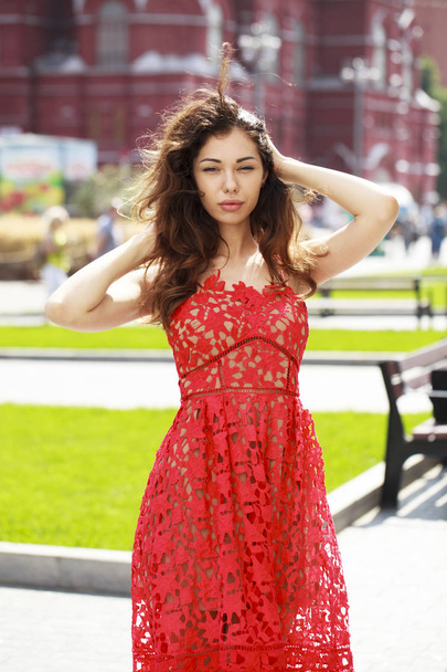 Beautiful brunette woman in sexy red dress - Фото, изображение