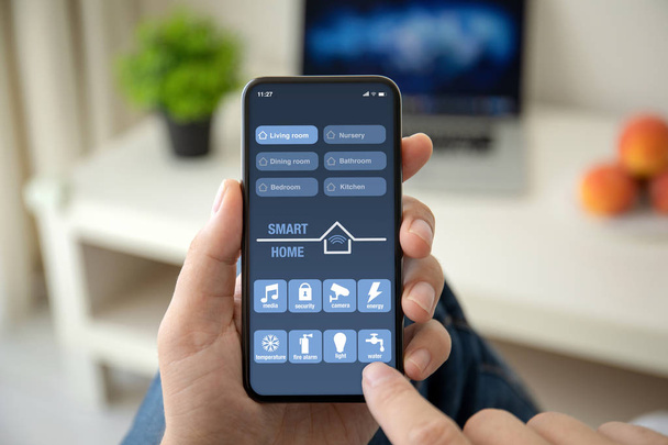 man hands holding phone with app smart home on screen - Photo, Image