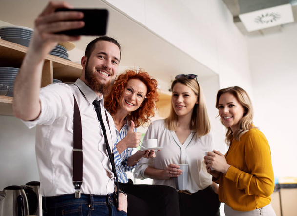 A group of young business people with smartphone at work, taking selfie. - Fotografie, Obrázek