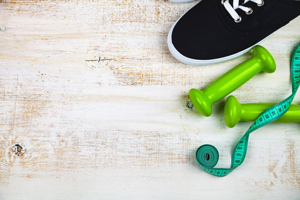 Sneakers, dumbbells and measuring tape  - Фото, изображение