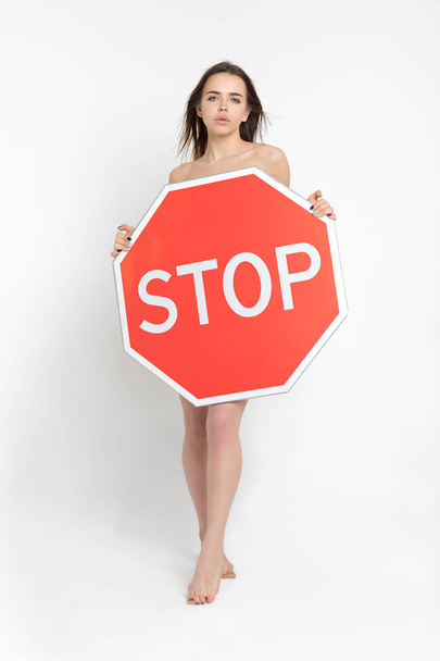 Сексуальна молода жінка тримає великий червоний знак стоп
. - Фото, зображення