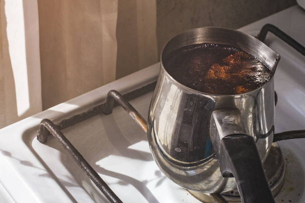バリスタは、銅タークから熱いおいしい飲み物を準備し、水を沸騰させます  - 写真・画像