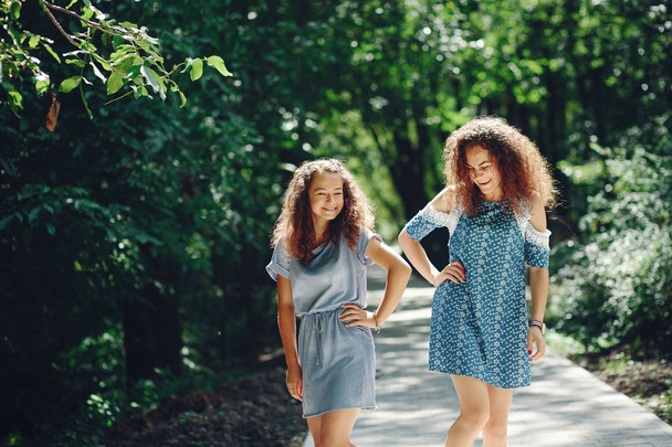 Two cute sisters in a summer park - 写真・画像