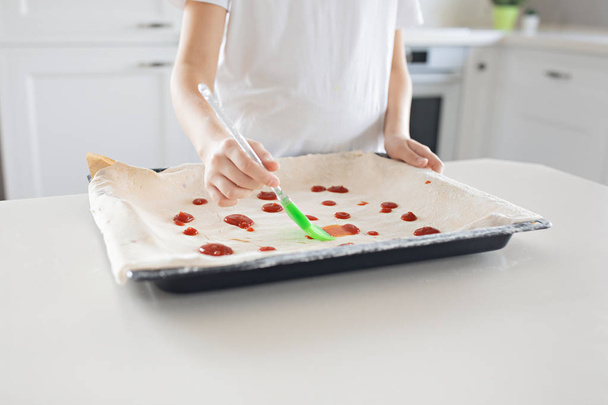 Un enfant prépare une pizza italienne à la maison. L'enfant lubrique
 - Photo, image