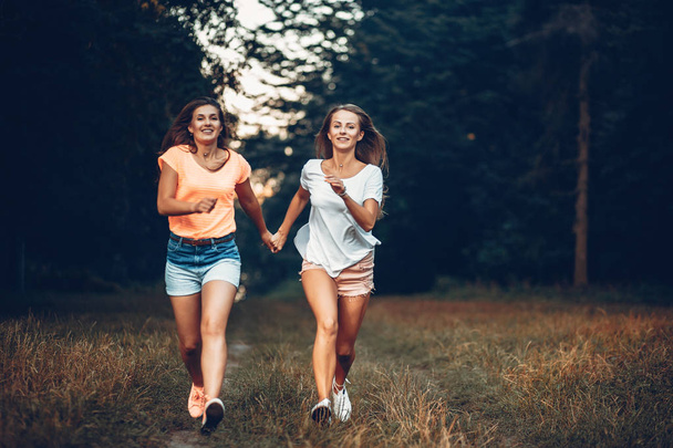 Two pretty girls in a summer park - Fotó, kép