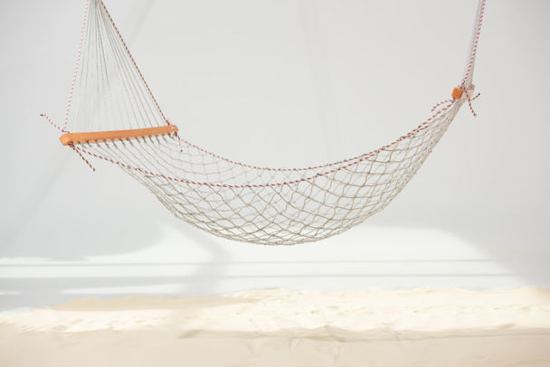 hanging hammock made of net over sand on grey - Photo, Image