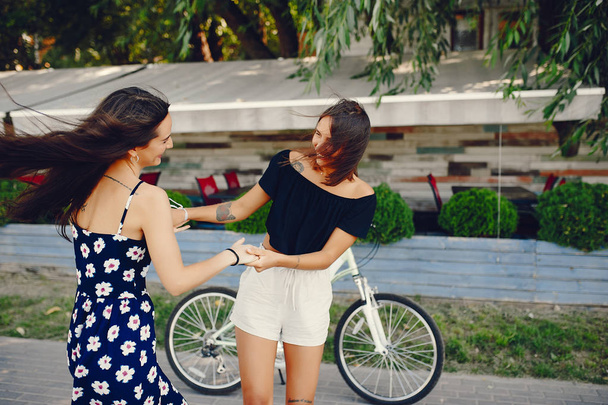 Stylish girls walking in a summer park - Zdjęcie, obraz