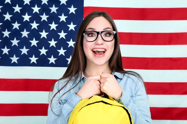 Joven estudiante con mochila sobre fondo de bandera americana
 - Foto, Imagen