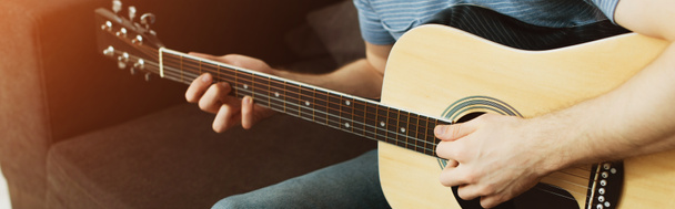 панорамный снимок музыканта, играющего на акустической гитаре дома
  - Фото, изображение