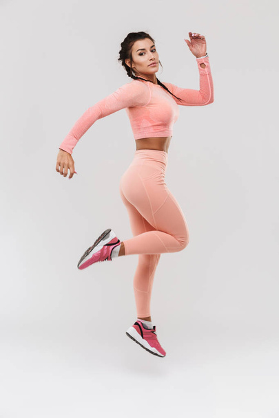 Young amazing strong sports fitness woman posing isolated over white wall background make exercises. - 写真・画像