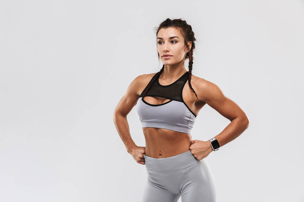 Amazing strong sports fitness woman posing isolated over white wall background. - Zdjęcie, obraz