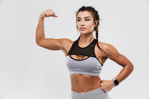Amazing strong sports fitness woman posing isolated over white wall background. - Zdjęcie, obraz
