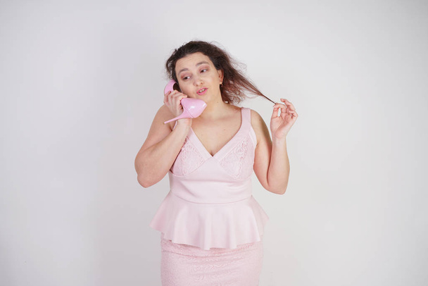 emotionaalinen pullea nainen vaaleanpunainen mekko puhuu ja juoruja Shoe kuin puhelimessa valkoinen Studio tausta
 - Valokuva, kuva