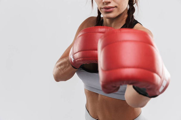 Beautiful young amazing strong sports fitness woman boxer posing isolated over white wall background make exercises with gloves. - Valokuva, kuva