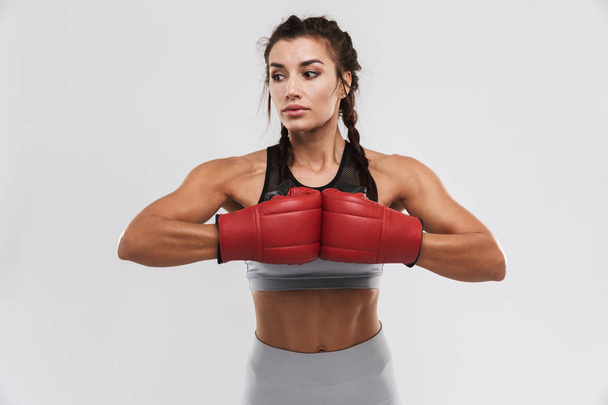 Beautiful young amazing strong sports fitness woman boxer posing isolated over white wall background make exercises with gloves. - Valokuva, kuva