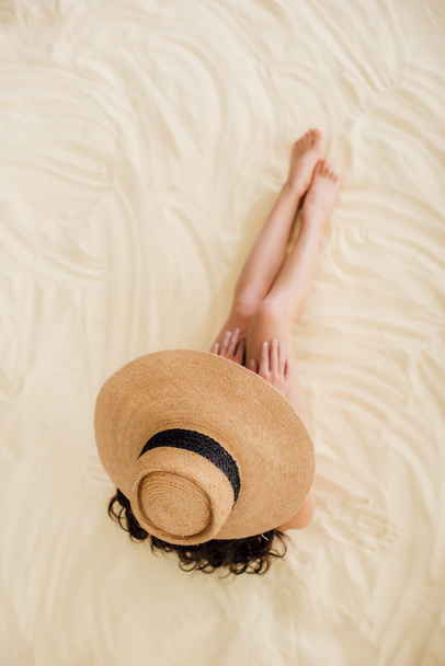 ylhäältä näkymä nuori nainen olkihattu rentouttava hiekkarannalla
 - Valokuva, kuva