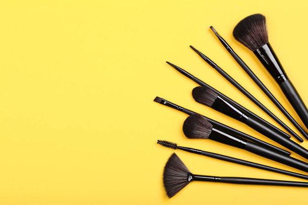 Set of makeup brushes on yellow background - Foto, afbeelding