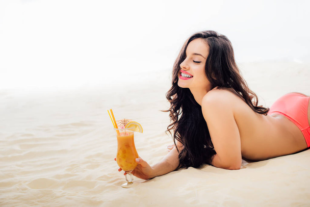 красива усміхнена дівчина топлес з коктейлем лежить на пляжі з копіювальним простором
 - Фото, зображення
