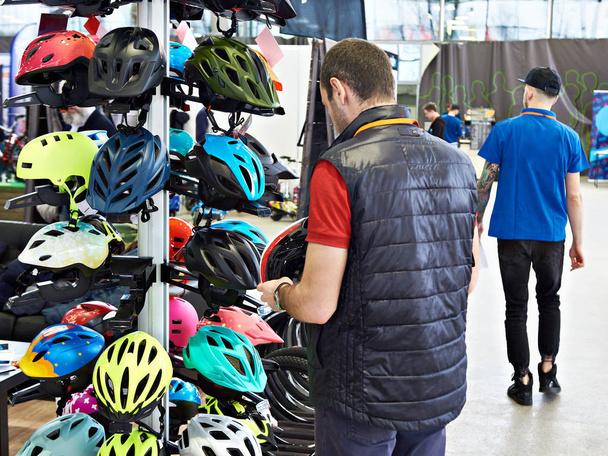 Homme acheteur choisit casque de sécurité pour le vélo
 - Photo, image