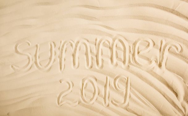 top view of summer 2019 written on wavy sand  - Photo, Image