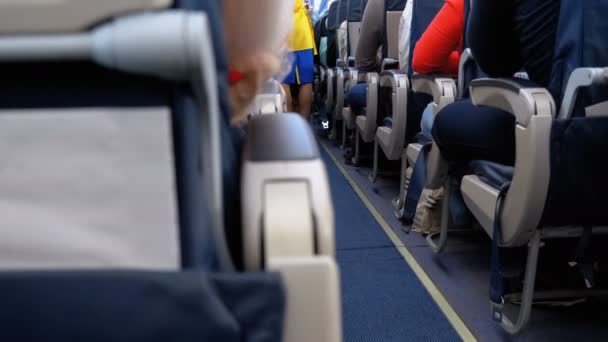 Pasażerowie wewnątrz kabiny samolotu pasażerskiego siedzący na krzeseł podczas lotu - Materiał filmowy, wideo