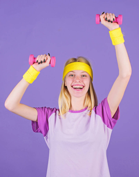 Easy exercises with dumbbells. Workout with dumbbells. Biceps exercises for women step by step guide. Girl hold dumbbells wear wristbands. Sport and fitness concept. Woman exercising with dumbbells - 写真・画像