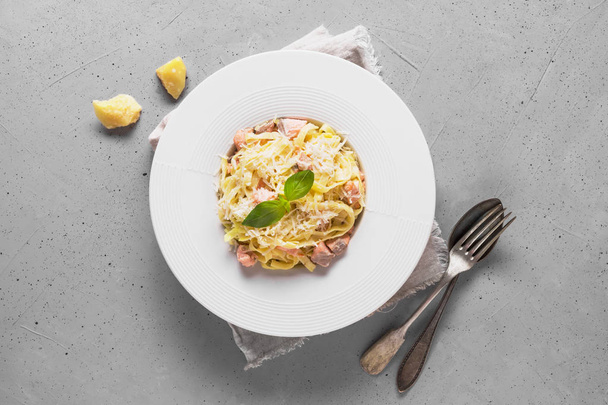 Pasta with trout and cream in white plate on light background. Delicious Mediterranean lunch. - Foto, immagini