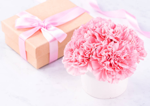 Copy space, close up, mock up, clipping path. Mothers day wording concept design. Beautiful fresh blooming baby pink color carnations isolated on bright marble background. - Photo, image