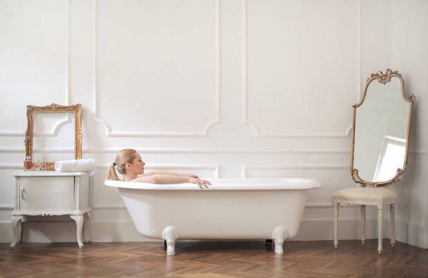 fiatal szőke nő pihentető fürdőkádban  - Fotó, kép