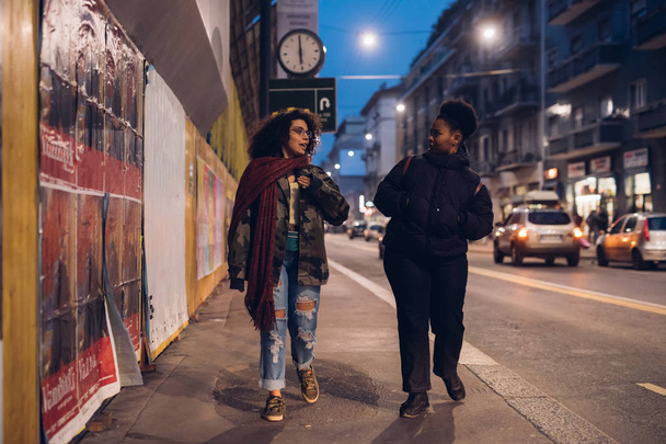 két barna és göndör lány sétál az utcán - Fotó, kép