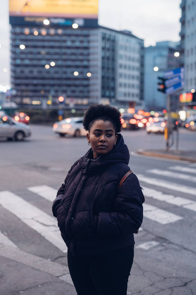 joven negro y rizado chica posando en la calle mirando hacia adelante
 - Foto, Imagen
