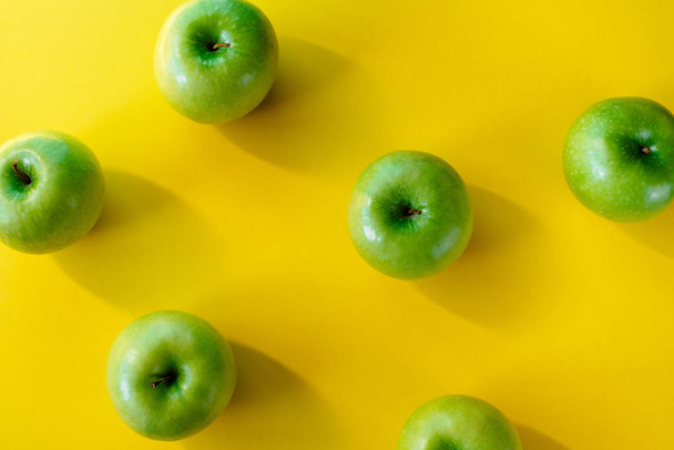 Group of green apples on yellow background - Fotoğraf, Görsel