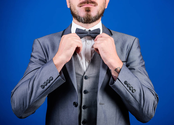 Formal suit jacket close up. Male fashion and aesthetic. Businessman formal outfit. Classic style aesthetic. Perfect suit fit him. Menswear shop. Hands fixing bow tie. Man adjust suit with bow tie - Photo, Image