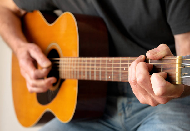 Человек играет на акустической гитаре - Фото, изображение