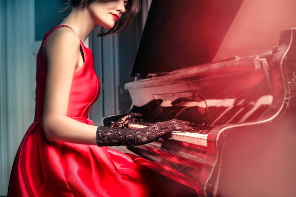 Beautiful young woman playing piano - 写真・画像
