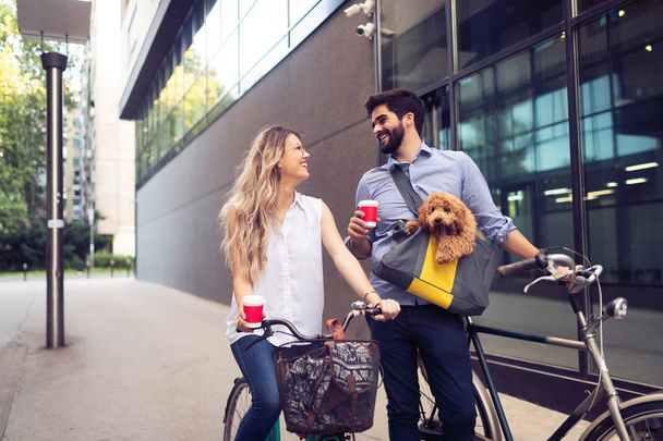 Attractive woman and handsome man spending time together with dog and bicycles - Foto, imagen