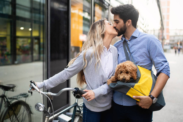 Attractive woman and handsome man spending time together with dog and bicycles - Foto, Imagen