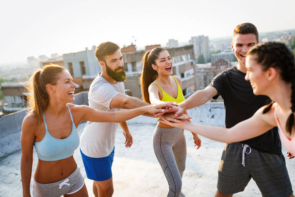 Grupo de personas felices en forma entrenando al aire libre en el techo - Foto, imagen